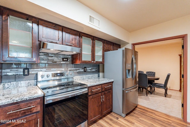 kitchen featuring dark brown cabinetry, under cabinet range hood, visible vents, appliances with stainless steel finishes, and backsplash