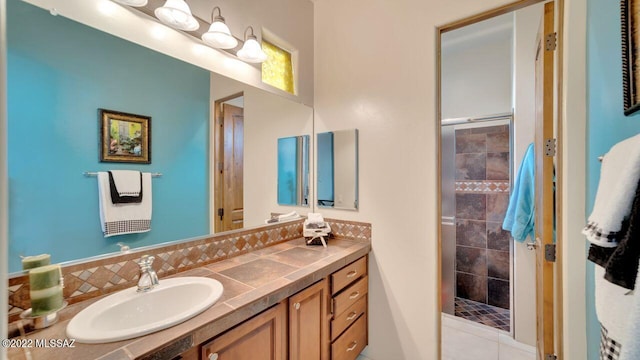 bathroom featuring tiled shower, decorative backsplash, and vanity