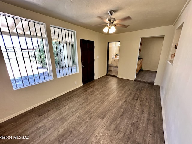 unfurnished room with dark wood-type flooring, ceiling fan, and a textured ceiling