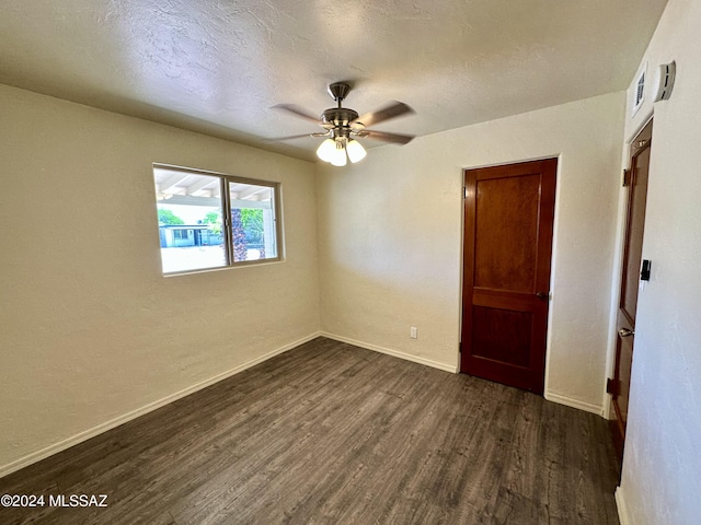 unfurnished room featuring ceiling fan, dark hardwood / wood-style floors, and a textured ceiling