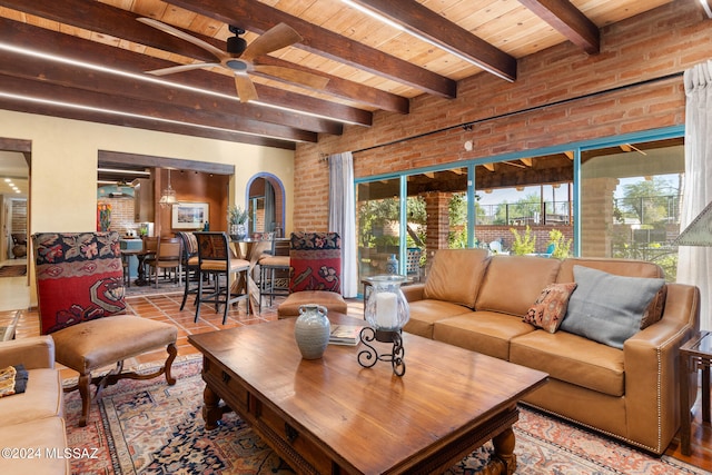 living room featuring brick wall, beamed ceiling, and plenty of natural light