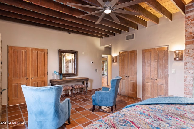 bedroom featuring dark tile patterned flooring, beam ceiling, ceiling fan, and wooden ceiling