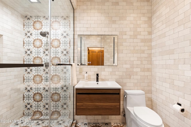 bathroom with walk in shower, vanity, tile walls, and toilet