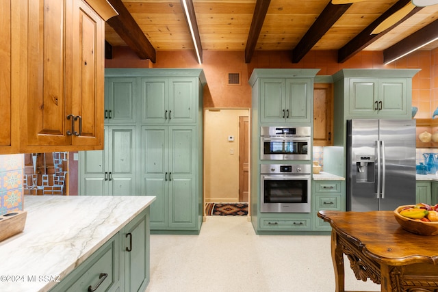 kitchen featuring light stone countertops, stainless steel appliances, green cabinetry, and beamed ceiling