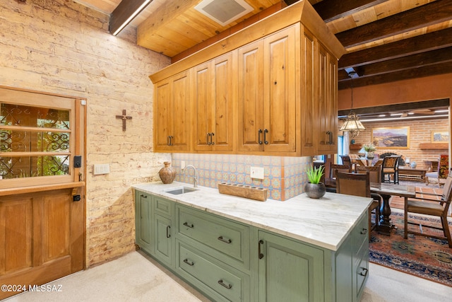 kitchen featuring light colored carpet, brick wall, beamed ceiling, and sink