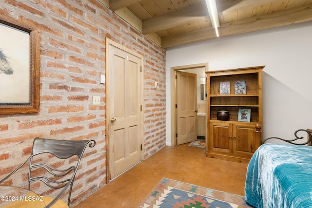 bedroom featuring brick wall, connected bathroom, beam ceiling, and wooden ceiling