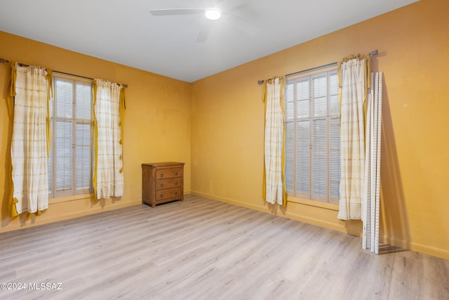 empty room with ceiling fan and light wood-type flooring