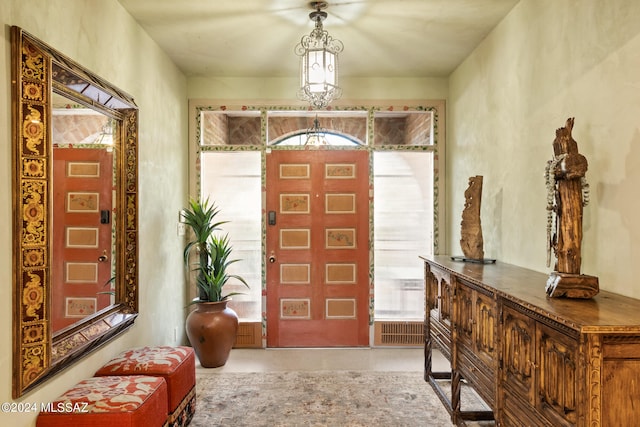 foyer entrance with concrete floors and a chandelier