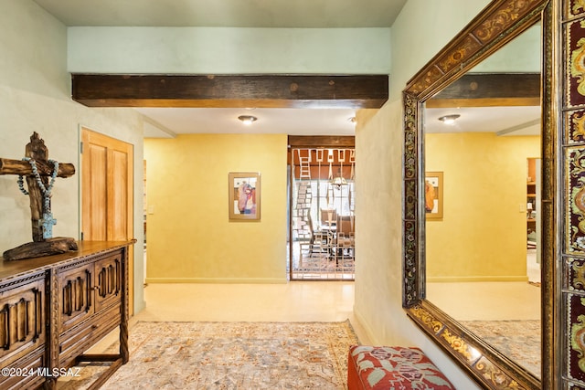 corridor with beam ceiling and light colored carpet