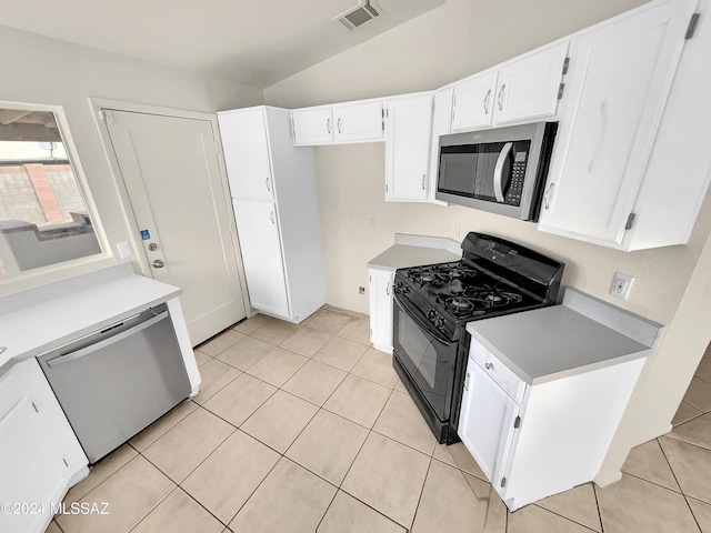 kitchen featuring white cabinetry, light tile patterned floors, stainless steel appliances, and lofted ceiling