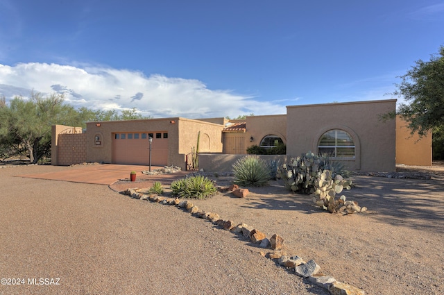 pueblo-style house featuring a garage