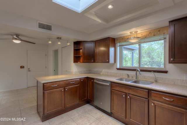 kitchen with a skylight, dishwasher, sink, light tile patterned floors, and kitchen peninsula