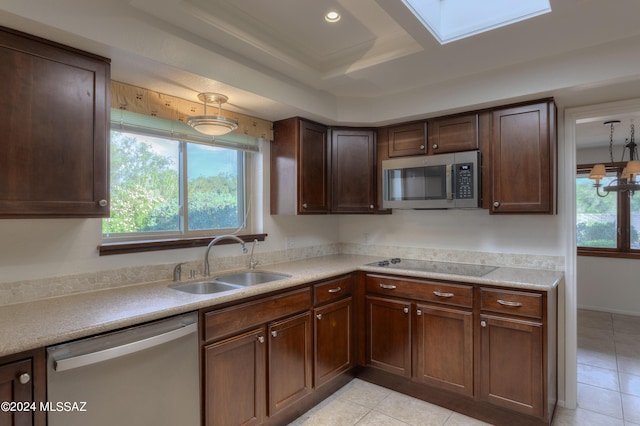 kitchen featuring a healthy amount of sunlight, appliances with stainless steel finishes, a tray ceiling, and sink