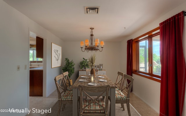 tiled dining space featuring an inviting chandelier