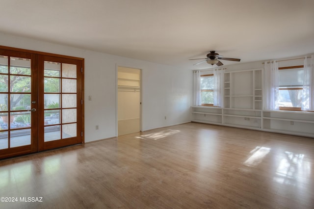 unfurnished room with french doors, ceiling fan, light wood-type flooring, and a wealth of natural light