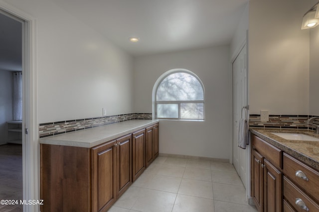 interior space with tasteful backsplash, vanity, and tile patterned flooring