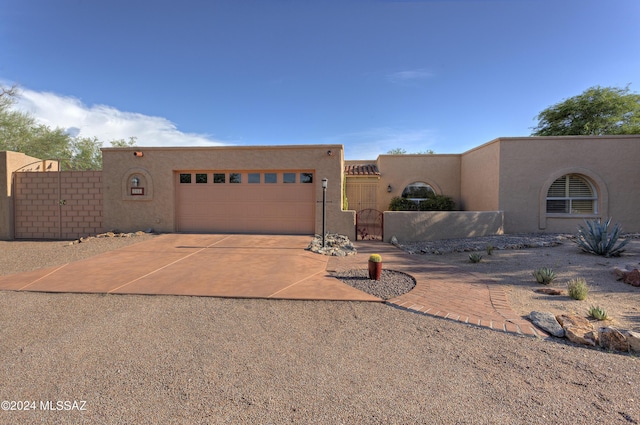 pueblo-style house featuring a garage