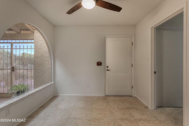 tiled empty room featuring a wealth of natural light and ceiling fan