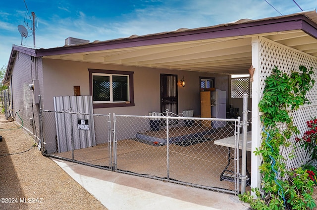 view of front of house with a gate, covered porch, stucco siding, and fence private yard