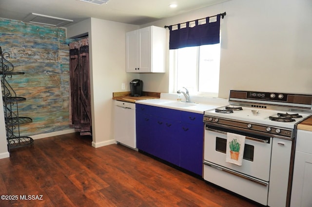 kitchen featuring a sink, white appliances, light countertops, dark wood finished floors, and baseboards