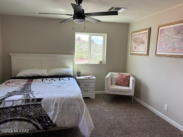 carpeted bedroom featuring baseboards, a ceiling fan, and visible vents