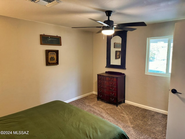 carpeted bedroom with visible vents, a ceiling fan, and baseboards
