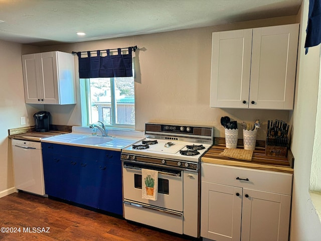 kitchen with blue cabinets, sink, dark hardwood / wood-style floors, white appliances, and white cabinets