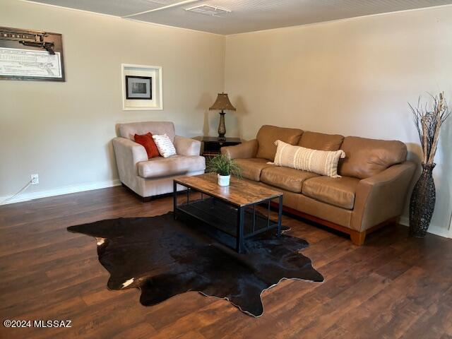 living room featuring baseboards, wood finished floors, and visible vents