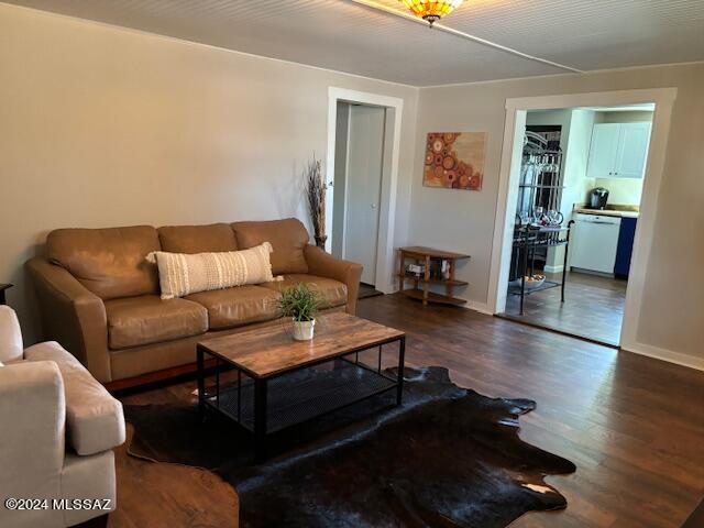 living area with baseboards and dark wood-type flooring