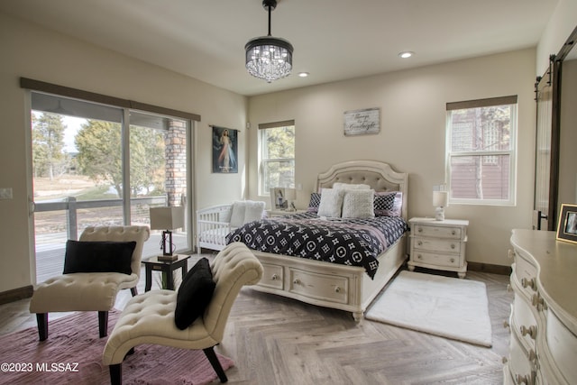 bedroom with a chandelier, a barn door, light parquet floors, and multiple windows