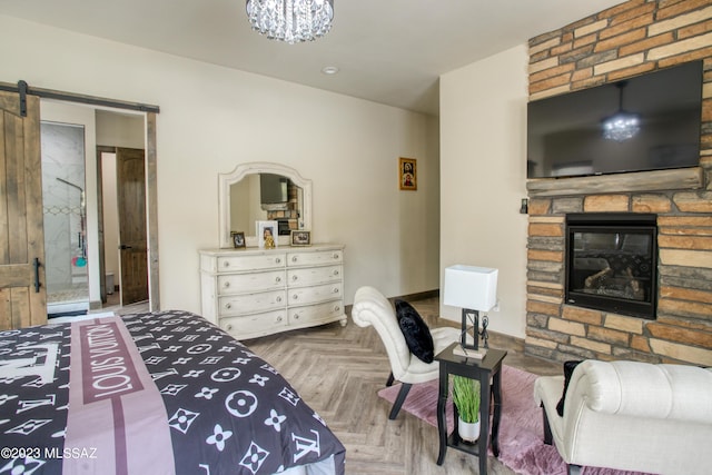 bedroom featuring a barn door, parquet flooring, and a fireplace