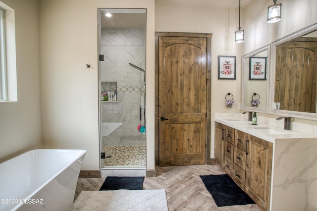 bathroom featuring parquet flooring, vanity, and separate shower and tub