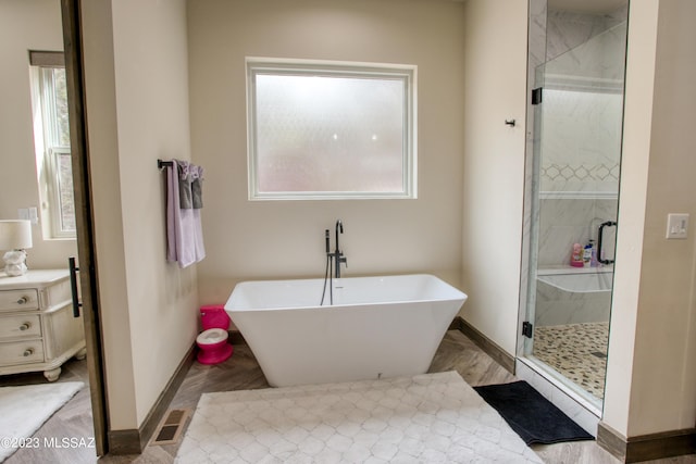 bathroom with hardwood / wood-style floors, separate shower and tub, and a healthy amount of sunlight