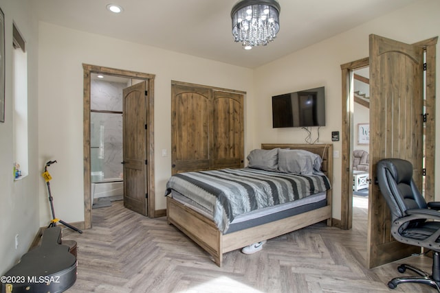 bedroom featuring a notable chandelier, light parquet flooring, and ensuite bath