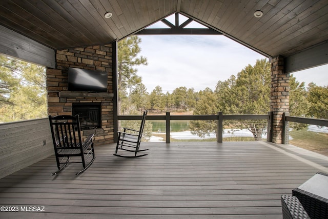 deck with an outdoor stone fireplace