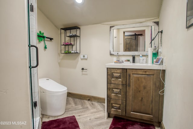 bathroom with parquet floors, vanity, vaulted ceiling, toilet, and a shower with shower door