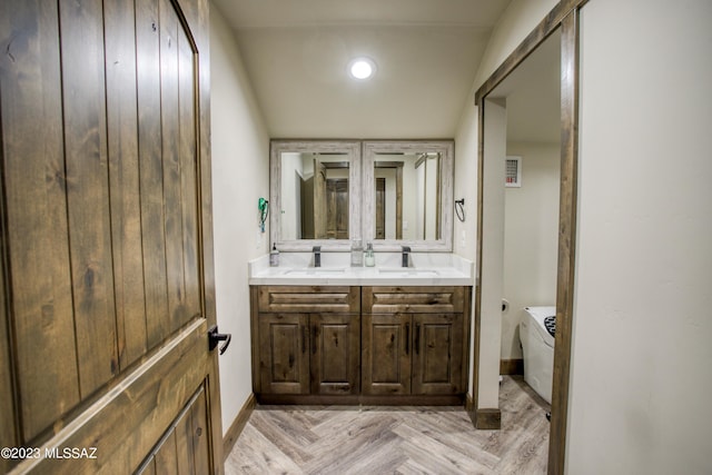 bathroom with vanity, parquet floors, vaulted ceiling, and toilet