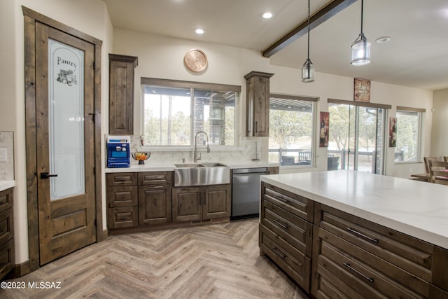 kitchen with dishwasher, light parquet floors, sink, hanging light fixtures, and tasteful backsplash