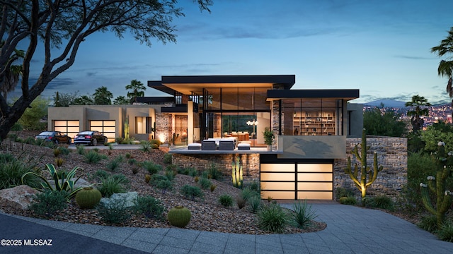 view of front of property with a balcony, stone siding, an outdoor hangout area, and stucco siding