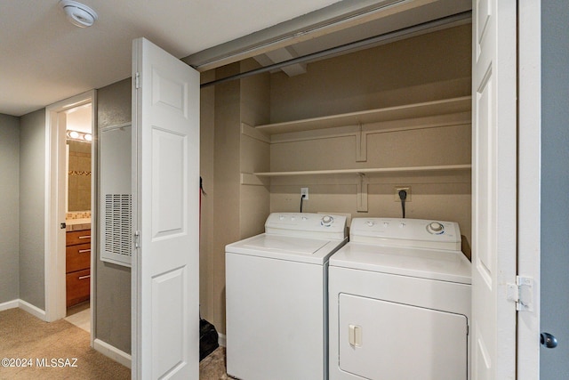 laundry room featuring washing machine and dryer and light colored carpet