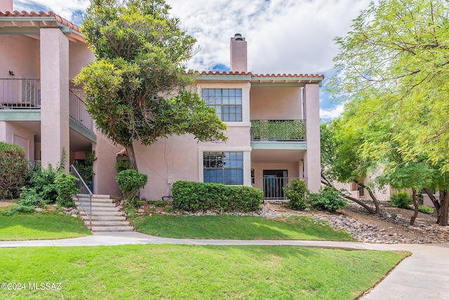 mediterranean / spanish-style home with a front lawn