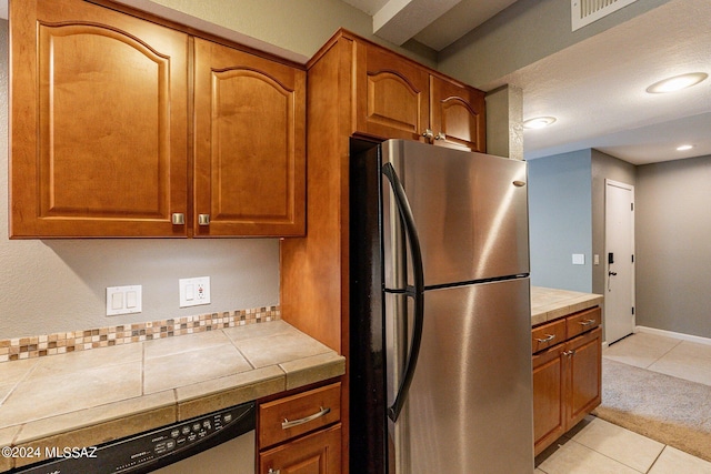 kitchen featuring tile countertops, light tile patterned floors, and stainless steel appliances