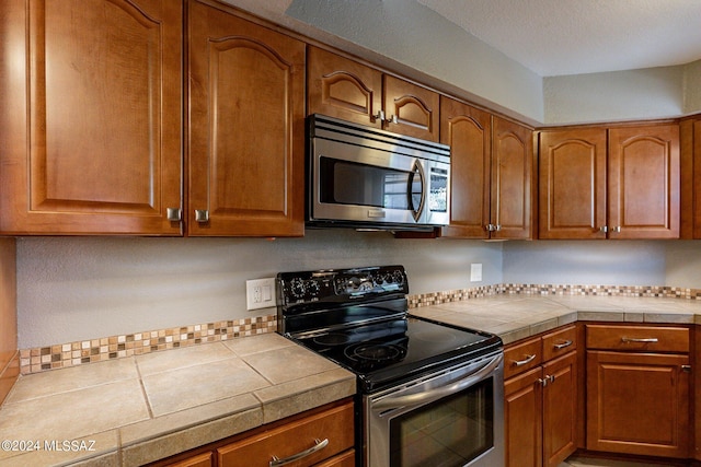 kitchen featuring tile countertops and appliances with stainless steel finishes