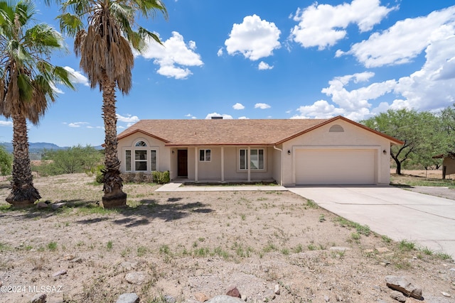 ranch-style home with a garage, driveway, and stucco siding
