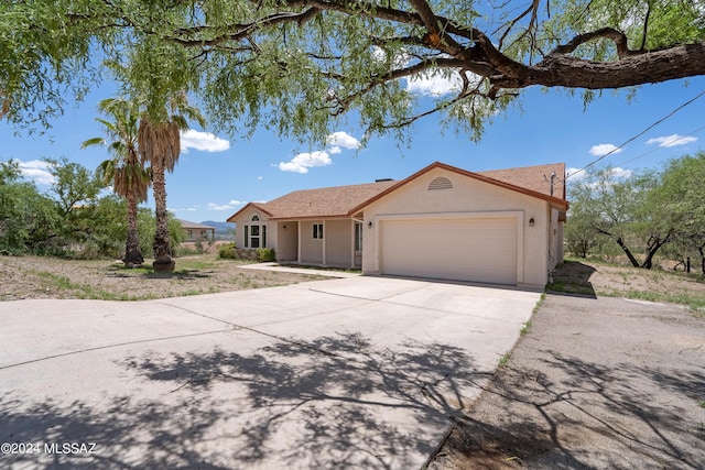 single story home with driveway, a garage, and stucco siding