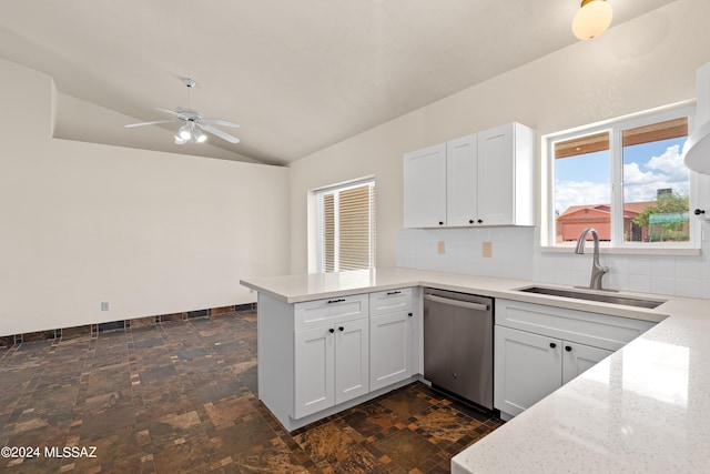 kitchen featuring dishwasher, a sink, a peninsula, decorative backsplash, and lofted ceiling