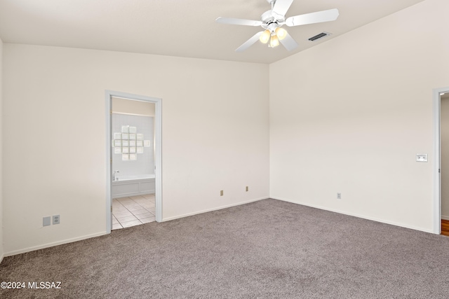 spare room with a ceiling fan, visible vents, tile patterned flooring, carpet flooring, and baseboards
