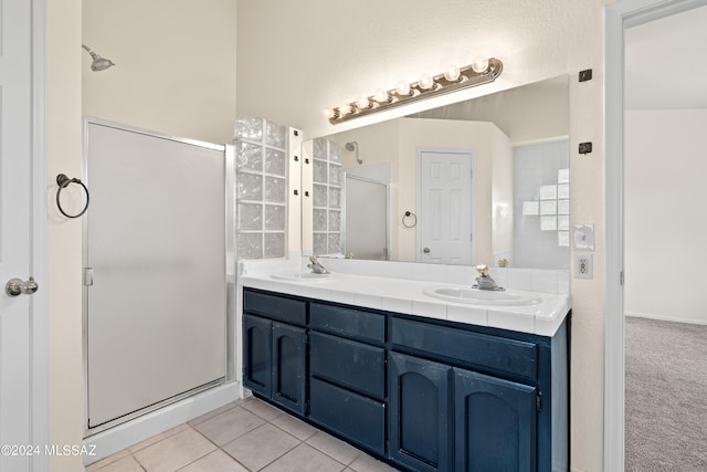 bathroom featuring a sink, tile patterned floors, double vanity, and a stall shower