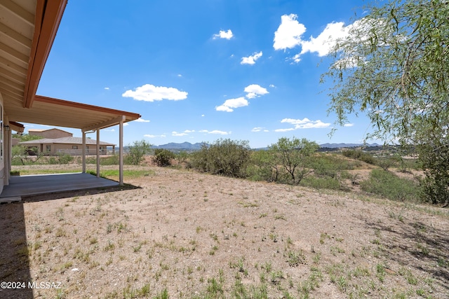 view of yard featuring a patio area and a mountain view