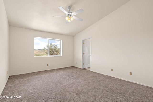 spare room featuring carpet floors, baseboards, a ceiling fan, and vaulted ceiling